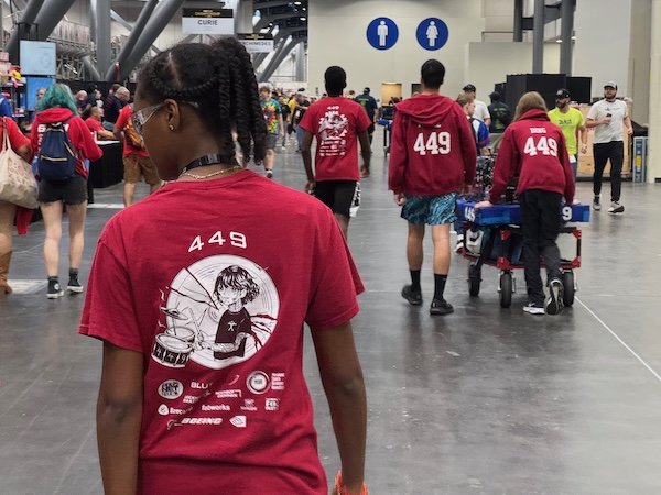 Team members in matching 449 shirts walking through the FIRST Championship convention center