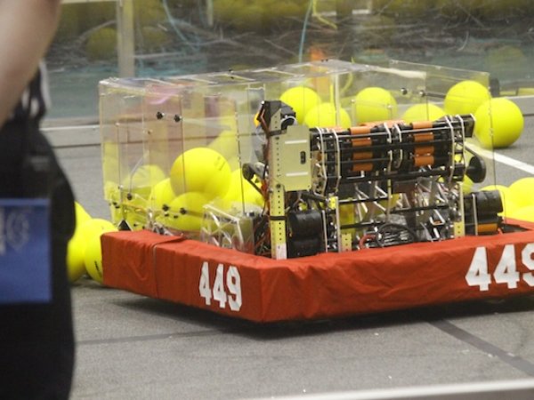 Team 449's robot on the competition field, surrounded by yellow game pieces