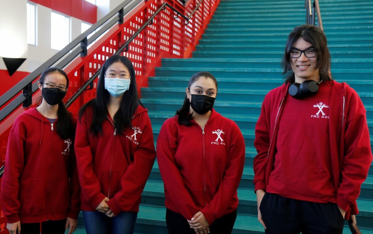 Team members in masks on the school stairwell